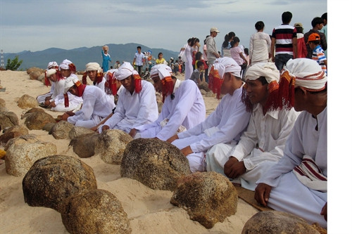 Con cháu mặc áo truyền thốngg làm lễ tảo mộ mời ông bà tổ tiên về vui Tết. Ảnh: Công Thử- TTXVN