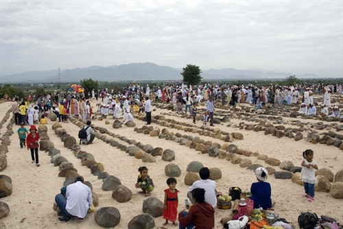 Đồng bào làm lễ tảo mộ mời ông bà tổ tiên về vui Tết. Ảnh: Công Thử- TTXVN