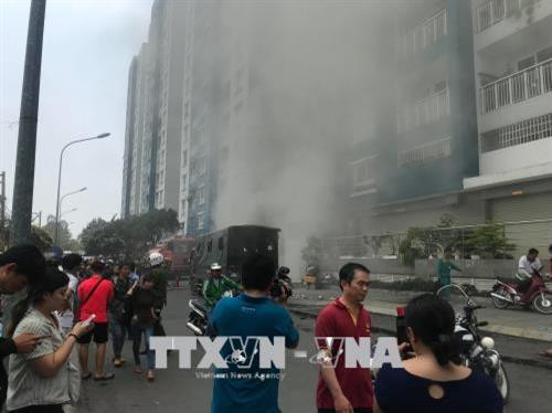 Khói bất ngờ bùng phát trở lại tại khu vực hầm để xe của chung cư Carina. Ảnh: Thành Chung - TTXVN