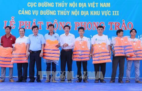 Trao áo phao cứu hộ cho chủ phương tiện giao thông đường thủy. Ảnh: Nam Thái – TTXVN Trao áo phao cứu hộ cho chủ phương tiện giao thông đường thủy. Ảnh: Nam Thái – TTXVN