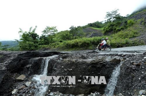 Sạt lở trên tuyến đường Quốc lộ 12 gây khó khăn cho người và các phương tiện tham gia giao thông. Ảnh: Phan Tuấn Anh - TTXVN