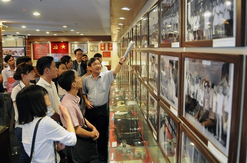 Đồng chí Nguyễn Tiến Lễ- Giám đốc Cơ quan TTXVN khu vực phía Nam giới thiệu với các học viên những hình ảnh, hiện vật trưng bày tại phòng truyền thống. Ảnh: An Hiếu- TTXVN