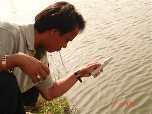 Anh Bùi Xuân Tương, chủ trang trai đang kiềm tra độ phèn ao nuôi cá chình