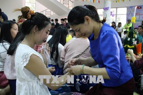 Buộc chỉ cổ tay là nghi lễ quan trọng trong Tết cổ truyền Bunpimay của người Lào. Ảnh: Diệp Anh - TTXVN Buộc chỉ cổ tay là nghi lễ quan trọng trong Tết cổ truyền Bunpimay của người Lào. Ảnh: Diệp Anh - TTXVN