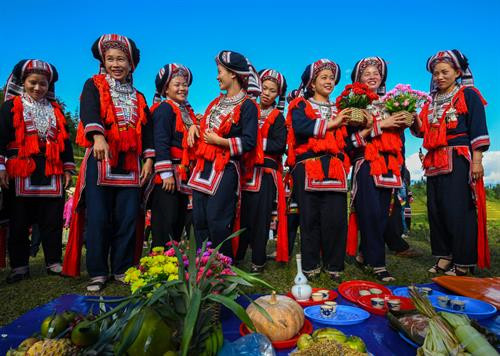 Bàn thờ treo bộ tranh thờ “Tam thanh” - 3 vị thần trong tín ngưỡng người Dao cai quản 3 nơi là Ngọc thanh (thần cai quản trên trời), Thượng thanh (thần cai quản trần gian) và Thái thanh (thần cai quản âm phủ). Theo truyền thuyết, tuy là vua nhưng Bàn Vương vẫn giữ thói quen sống giản dị, gần gũi với thiên nhiên. Ngài luôn căn dặn các con phải chăm chỉ lao động sản xuất. Có một lần, Bàn Vương cùng tùy tùng lên núi săn bắn, đuổi theo một con sơn dương bị thương, chẳng may bị sơn dương húc, ngài ngã vào cây gù hương và mất tại đó. Thi thể Bàn Vương bị vướng trên nhành cây, các con bèn chặt cây làm thân trống, đuổi bắt con sơn dương để lấy da làm trống tế lễ Bàn Vương. Từ đó. cứ đến khoảng tháng 2 Âm lịch hàng năm, con cháu người Dao từ đời này sang đời khác phải nhớ ngày cúng giỗ Bàn Vương, thể hiện sự biết ơn với tổ tiên đã sinh ra họ. Người dân các thôn chuẩn bị lễ vật, chờ đến giờ tốt để dâng lên Bàn Vương. Các thầy cúng bắt đầu thay lễ phục, giúp nhau sửa soạn mũ áo. Chân dung một trong số sáu thầy cúng của buổi lễ. Ông Triệu Chòi Quyên, thầy cúng trong xã, cho biết: "Các thầy cúng sẽ hát những bài ca cúng để nhờ thần linh, thổ địa nghênh đón Bàn Vương xuống đàn, nhận lễ vật của con cháu dâng lên". Sau mỗi lời khấn bằng tiếng Dao, thầy cúng và người dân các thôn cùng quỳ lạy Bàn Vương. Các điệu múa chuông, múa bắt rùa... lần lượt được các thầy cúng thực hiện sau khi mời để tái hiện lại tiểu sử của Bàn Vương năm xưa như vóc dáng, cách hái lượm săn bắn. Việc này theo các thầy cúng vừa để thể hiện ý chí, sức mạnh sinh tồn của người xưa, vừa để nhắc nhở con cháu ngày nay cần cù, chịu khó làm ăn như cha ông trước đây. Theo ông Quyên, vật chày là một trò chơi dân gian thể hiện sức mạnh, sự kết hợp khéo léo, sự bí ẩn của cả người gánh và người vật. Sau khi thầy cúng làm phép nhờ thần linh giúp đỡ, dù rất đông người cùng tham gia nhưng không thể ấn nổi đầu chày chạm đất. Điều này thể hiện việc bản làng năm đó được các vị thần phù hộ, nâng đỡ. Người dân tới dâng lễ và tham gia lễ hội Bàn Vương. Bàn thờ treo bộ tranh thờ “Tam thanh” - 3 vị thần trong tín ngưỡng người Dao cai quản 3 nơi là Ngọc thanh (thần cai quản trên trời), Thượng thanh (thần cai quản trần gian) và Thái thanh (thần cai quản âm phủ). Theo truyền thuyết, tuy là vua nhưng Bàn Vương vẫn giữ thói quen sống giản dị, gần gũi với thiên nhiên. Ngài luôn căn dặn các con phải chăm chỉ lao động sản xuất. Có một lần, Bàn Vương cùng tùy tùng lên núi săn bắn, đuổi theo một con sơn dương bị thương, chẳng may bị sơn dương húc, ngài ngã vào cây gù hương và mất tại đó. Thi thể Bàn Vương bị vướng trên nhành cây, các con bèn chặt cây làm thân trống, đuổi bắt con sơn dương để lấy da làm trống tế lễ Bàn Vương. Từ đó. cứ đến khoảng tháng 2 Âm lịch hàng năm, con cháu người Dao từ đời này sang đời khác phải nhớ ngày cúng giỗ Bàn Vương, thể hiện sự biết ơn với tổ tiên đã sinh ra họ. Người dân các thôn chuẩn bị lễ vật, chờ đến giờ tốt để dâng lên Bàn Vương. Các thầy cúng bắt đầu thay lễ phục, giúp nhau sửa soạn mũ áo. Chân dung một trong số sáu thầy cúng của buổi lễ. Ông Triệu Chòi Quyên, thầy cúng trong xã, cho biết: "Các thầy cúng sẽ hát những bài ca cúng để nhờ thần linh, thổ địa nghênh đón Bàn Vương xuống đàn, nhận lễ vật của con cháu dâng lên". Sau mỗi lời khấn bằng tiếng Dao, thầy cúng và người dân các thôn cùng quỳ lạy Bàn Vương. Các điệu múa chuông, múa bắt rùa... lần lượt được các thầy cúng thực hiện sau khi mời để tái hiện lại tiểu sử của Bàn Vương năm xưa như vóc dáng, cách hái lượm săn bắn. Việc này theo các thầy cúng vừa để thể hiện ý chí, sức mạnh sinh tồn của người xưa, vừa để nhắc nhở con cháu ngày nay cần cù, chịu khó làm ăn như cha ông trước đây. Theo ông Quyên, vật chày là một trò chơi dân gian thể hiện sức mạnh, sự kết hợp khéo léo, sự bí ẩn của cả người gánh và người vật. Sau khi thầy cúng làm phép nhờ thần linh giúp đỡ, dù rất đông người cùng tham gia nhưng không thể ấn nổi đầu chày chạm đất. Điều này thể hiện việc bản làng năm đó được các vị thần phù hộ, nâng đỡ. Người dân tới dâng lễ và tham gia lễ hội Bàn Vương.