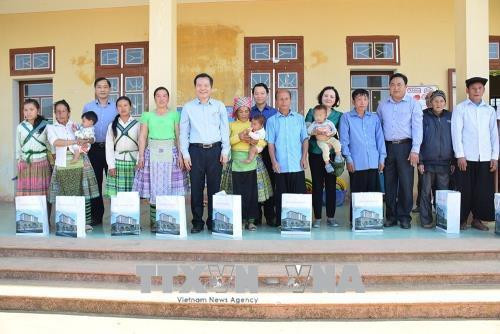 Đồng chí Phùng Quốc Hiển tặng cho các hộ dân bị thiệt hại do bão lũ ở xã Bản Công, huyện Trạm tấu. Ảnh: Đỗ Tuấn Anh-TTXVN