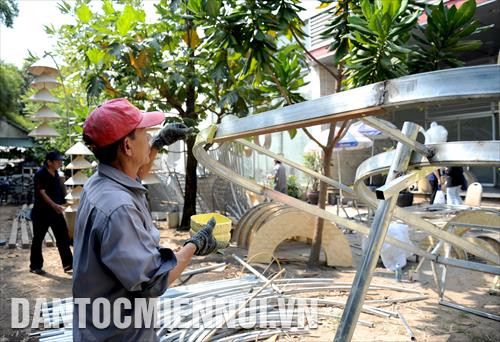 Các công nhân tất bật thực hiện một công đoạn thiết kế các tiểu cảnh của Đường hoa Nguyễn Huệ Tết Canh Tý 2020