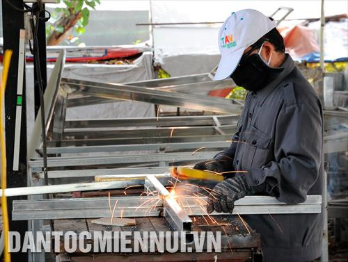 Các công nhân tất bật thực hiện một công đoạn thiết kế các tiểu cảnh của Đường hoa Nguyễn Huệ Tết Canh Tý 2020