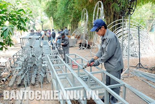Các công nhân tất bật thực hiện một công đoạn thiết kế các tiểu cảnh của Đường hoa Nguyễn Huệ Tết Canh Tý 2020