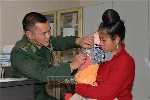 Cán bộ quân y Đồn Biên phòng Phiêng Pằn khám bệnh cho người dân em vùng biên. Ảnh: Hữu Quyết - TTXVN