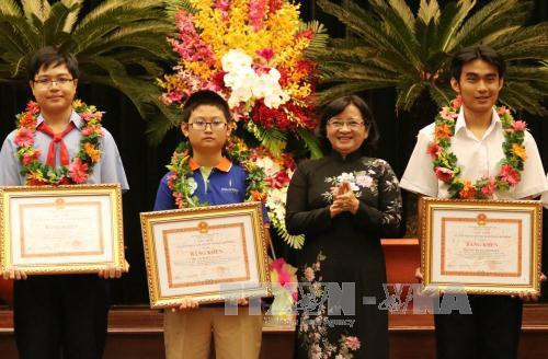 Bà Thân Thị Thư, Trưởng ban Tuyên giáo Thành ủy Thành phố Hồ Chí Minh trao Bằng khen cho các học sinh giỏi năm học 2016 - 2017. Ảnh: Phương Vy - TTXVN
