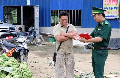 Thiếu tá Nguyễn Thành Long, Chính trị viên Đồn Biên phòng cửa khẩu Ma Lù Thàng, tuyên truyền vận động bà con nhân dân vùng viên nghiêm chỉnh chấp hành nội quy, quy chế về giao thương tại khu vực biên giới. Ảnh: Công Tuyên – TTXVN