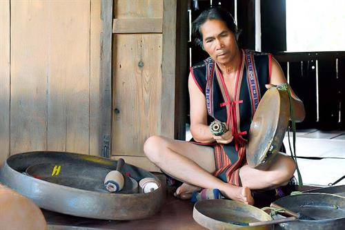 Nghệ nhân Rơ Châm H'Mút bên bộ chiêng quý Nghệ nhân Rơ Châm H'Mút bên bộ chiêng quý