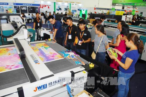 Khách tham quan các gian hàng trưng bày về máy móc thiết bị ngành in. Ảnh: Mạnh Linh-TTXVN