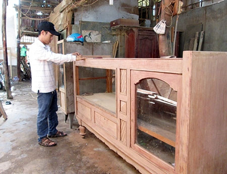 Anh Kim đang tranh thủ chà nhám chiếc tủ vừa mới đóng xong. Anh Kim đang tranh thủ chà nhám chiếc tủ vừa mới đóng xong.