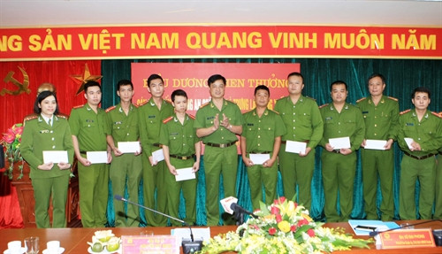 Đại tá Nguyễn Duy Ngọc, Phó Giám đốc Công an Hà Nội, Thủ trưởng Cơ quan Cảnh sát điều tra Công an Hà Nội tặng quà của Công an Hà Nội cho các tập thể và cá nhân có thành tích xuất sắc. Ảnh: Doãn Tấn - TTXVN