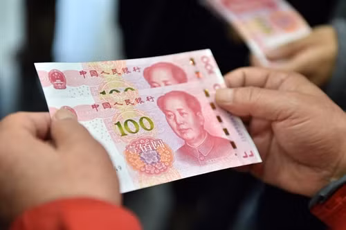 Trong ảnh: Tờ 100 Nhân dân tệ mới được rút từ máy ATM ở thủ đô Bắc Kinh ngày 12/11. THX/TTXVN