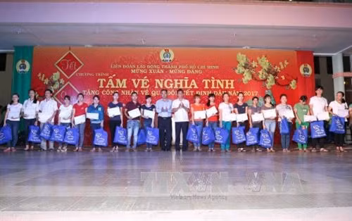Lãnh đạo Thành phố Hồ Chí Minh và các doanh nghiệp trao tặng quà và tấm vé nghĩa tình cho công nhân về quê đón Tết. Ảnh: Thanh Vũ - TTXVN
