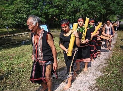 Già làng và người dân dẫn đoàn đi lấy nước từ đầu làng để về thực hiện nghi lễ mừng lúa mới. Ảnh: Trọng Đạt - TTXVN