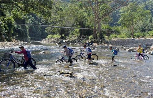 Học sinh Trường Tiểu học Yên Nhân, xã Yên Nhân, huyện miền núi Thường Xuân vượt suối đến trường. Ảnh: Nguyễn Nam-TTXVN