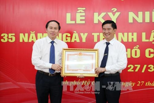 Thứ trưởng Bộ Tư pháp Lê Tiến Châu (bên trái) trao Bằng khen của Thủ tướng Chính phủ cho Sở Tư pháp Thành phố Hồ Chí Minh. Ảnh: Mạnh Linh-TTXVN