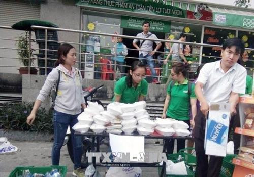 Nhân viên Co.opFood Carina chuẩn bị các phần cơm hỗ trợ người dân gặp nạn. Ảnh: Mỹ Phương –TTXVN