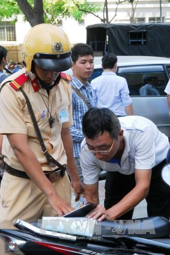 CSGT lập biên bản chủ phương tiện đậu xe ô tô đậu trên vỉa hè đường Hàm Nghi. Ảnh: Mạnh Linh - TTXVN CSGT lập biên bản chủ phương tiện đậu xe ô tô đậu trên vỉa hè đường Hàm Nghi. Ảnh: Mạnh Linh - TTXVN