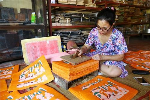 Tranh Đông Hồ được in trên giấy Điệp - loại giấy được làm thủ công từ việc quết hồ Điệp lên 1 mặt của tờ giấy Dó. Ảnh: Minh Quyết - TTXVN