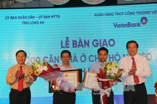 Bí thư tỉnh ủy Long An Phạm Văn Rạnh trao bằng khen cho lãnh đạo ngân hàng Viettinbank. Ảnh: Thanh Bình - TTXVN