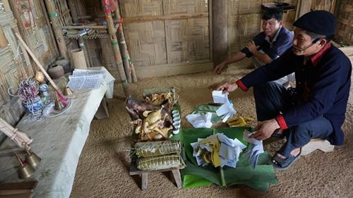 Thầy cúng dâng tiền vàng và rót rượu mời thần linh, ông bà tổ tiên về chứng giám lòng thành của con cháu. Ảnh: Hoàng Tâm