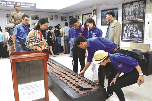 Du khách tham quan phòng trưng bày hiện vật, hình ảnh và chiếu phim tư liệu về các hành động tra tấn dã man tù binh tại Khu di tích Du khách tham quan phòng trưng bày hiện vật, hình ảnh và chiếu phim tư liệu về các hành động tra tấn dã man tù binh tại Khu di tích