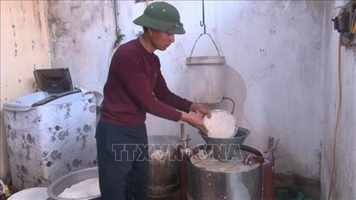 Gạo được ngâm với nước khoảng nửa ngày cho mềm, sau đó để ráo và cho vào máy nghiền thành chất bột lỏng. Ảnh: Khiếu Tư - TTXVN