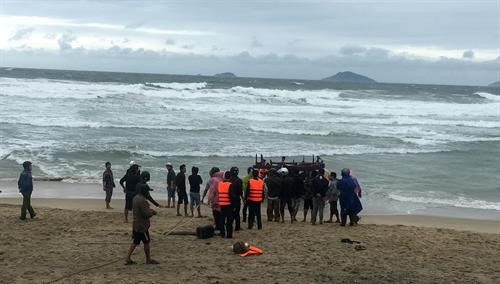 Cán bộ, chiến sĩ Đồn biên phòng Cửa Đại kéo tàu bị trôi dạt ngoài biển vào bờ. Ảnh: Đổ Trưởng-TTXVN Cán bộ, chiến sĩ Đồn biên phòng Cửa Đại kéo tàu bị trôi dạt ngoài biển vào bờ. Ảnh: Đổ Trưởng-TTXVN