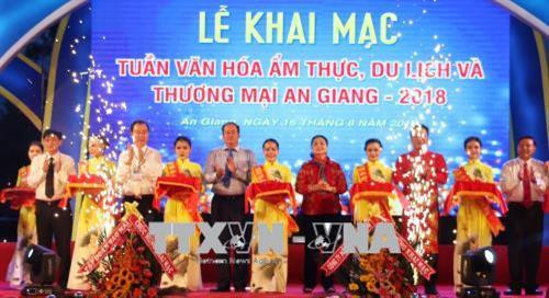Ban tổ chức cắt băng khai mạc Tuần lễ Văn hóa ẩm thực, Du lịch và Thương mại An Giang 2018. Ảnh: Công Mạo -TTXVN