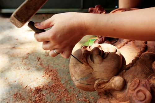 Người dân làng Thiết Úng với bàn tay khéo léo đục những nét sinh động trên sản phẩm đồ gỗ.