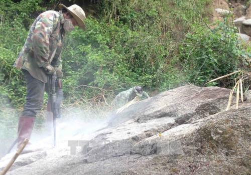 Công nhân phá đá khắc phục sạt lở tại Km36+050, Quốc lộ 27, thuộc địa bàn xã Yang Tao, huyện Lắk. Ảnh: Phạm Cường-TTXVN