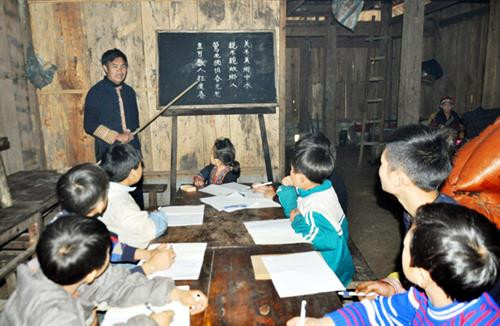 Nghệ nhân Tẩn Vần Siệu dạy chữ Nôm Dao cho trẻ em xã Tả Phìn.