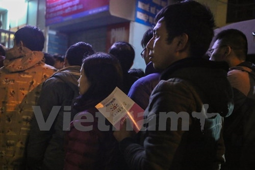 Ai cũng sẵn sàng trong tay sổ tiêm chủng của con mình. (Ảnh: Minh Sơn/Vietnam+)