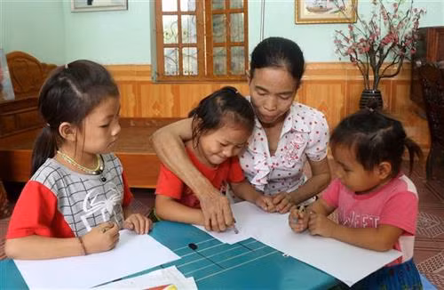 Hiện cô Nguyễn Thị Thanh Minh đang chăm sóc và nuôi dưỡng 3 trẻ người Mông. Ảnh: Quốc Khánh - TTXVN