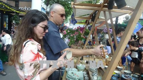 Du khách quốc tế mua sắm sản phẩm lưu niệm. Ảnh: Gia Thuận – TTXVN Du khách quốc tế mua sắm sản phẩm lưu niệm. Ảnh: Gia Thuận – TTXVN