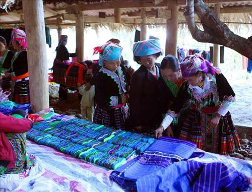 Bà con mua vải may quần áo. Ảnh: Quý Trung - TTXVN Bà con mua vải may quần áo. Ảnh: Quý Trung - TTXVN