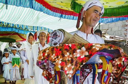 Lễ cuới Chăm Bà ni có 5 đứa trẻ, mặc bộ áo truyền thống màu trắng gọi là “Anak là con” để chứng giám cuộc hôn nhân và mang lễ vật Cô dâu Chú rể với bộ y phục cho lễ cưới toàn màu trắng tiến vào hành lễ trong rạp lễ Bắt đầu lễ các vị tu sĩ làm lễ đốt trầm hương. Sư Cả (Po Gru), đọc kinh Koran xin phép với vị thánh Alla. Những người thân của cô dâu chú rể cầu nguyện thánh Alla ban phước lành cho cô dâu và chú rể Chú rể, cô dâu lần lượt lạy tạ Sư Cả và các giáo sĩ - tục lệ khi lạy tấm khăn trắng trùm dưới 2 chân bằng khăn đội đầu của cô dâu Cô dâu được đưa về phòng the trước để thầy Chang (Po Car) đọc thần chú làm phép dưới đôi gối nằm Thầy Chang đọc thần chú làm phép nhẫn cưới trong lòng bàn tay của cô dâu, rồi đeo nhẫn cho cô dâu sau khi cô dâu trả lời với thầy Chang là đồng ý cuộc hôn nhân Chú rễ ở lại trong rạp lễ Kajang likhah được sư Cả đọc kinh Koran và các giáo sĩ làm phép trao nhẫn cưới Thầy Chang cầm tay chú rể dẫn đến với cô dâu. Hai giáo sĩ đi trước, chú rể đi sau và những em bé “Anak là con” Trong phòng the vị tu sĩ đặt tay chú rể được vào bàn tay cô dâu làm phép rửa tội cầu phúc Người vợ lấy một miếng trầu cau bỏ vào miệng chồng như ý bảo rằng từ nay nàng sẽ lo cho chàng đầy đủ sự ăn uống Trong thời gian 3 ngày đêm đầu vợ chồng phải sinh hoạt ăn uống trong phòng và có người ngồi giám sát Lễ cuới Chăm Bà ni có 5 đứa trẻ, mặc bộ áo truyền thống màu trắng gọi là “Anak là con” để chứng giám cuộc hôn nhân và mang lễ vật Cô dâu Chú rể với bộ y phục cho lễ cưới toàn màu trắng tiến vào hành lễ trong rạp lễ Bắt đầu lễ các vị tu sĩ làm lễ đốt trầm hương. Sư Cả (Po Gru), đọc kinh Koran xin phép với vị thánh Alla. Những người thân của cô dâu chú rể cầu nguyện thánh Alla ban phước lành cho cô dâu và chú rể Chú rể, cô dâu lần lượt lạy tạ Sư Cả và các giáo sĩ - tục lệ khi lạy tấm khăn trắng trùm dưới 2 chân bằng khăn đội đầu của cô dâu Cô dâu được đưa về phòng the trước để thầy Chang (Po Car) đọc thần chú làm phép dưới đôi gối nằm Thầy Chang đọc thần chú làm phép nhẫn cưới trong lòng bàn tay của cô dâu, rồi đeo nhẫn cho cô dâu sau khi cô dâu trả lời với thầy Chang là đồng ý cuộc hôn nhân Chú rễ ở lại trong rạp lễ Kajang likhah được sư Cả đọc kinh Koran và các giáo sĩ làm phép trao nhẫn cưới Thầy Chang cầm tay chú rể dẫn đến với cô dâu. Hai giáo sĩ đi trước, chú rể đi sau và những em bé “Anak là con” Trong phòng the vị tu sĩ đặt tay chú rể được vào bàn tay cô dâu làm phép rửa tội cầu phúc Người vợ lấy một miếng trầu cau bỏ vào miệng chồng như ý bảo rằng từ nay nàng sẽ lo cho chàng đầy đủ sự ăn uống Trong thời gian 3 ngày đêm đầu vợ chồng phải sinh hoạt ăn uống trong phòng và có người ngồi giám sát
