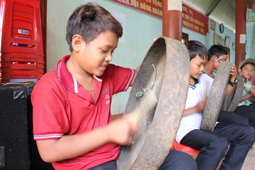 Các em chăm chỉ tập chơi chiêng đồng.