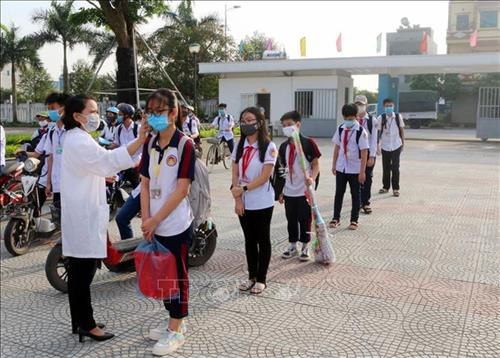 Học sinh trường chuyên Biên Hòa (thành phố Phủ Lý, tỉnh Hà Nam) được kiểm tra thân nhiệt trước khi vào lớp. Ảnh: Đại Nghĩa- TTXVN