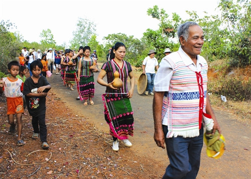 Già làng dẫn đường cùng phụ nữ, người dân trong bon mang bầu đựng nước ra bến nước làm lễ