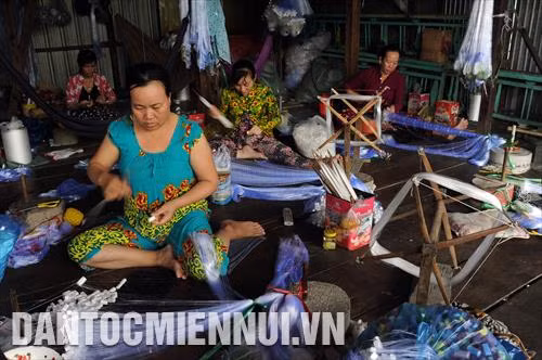 Mùa nước nổi năm nay tại Đồng bằng sông Cửu Long về sớm và được dự báo mực nước có thể cao hơn những năm trước. Những ngày này, không khí làm việc tại các cơ sở đan lưới thuộc xã Vĩnh Tế (thành phố Châu Đốc, An Giang) rất nhộn nhịp. Đây là thời điểm các hộ dân làm lưới chạy hết công suất để sản xuất hàng giao cho khách, phục vụ nhu cầu đánh bắt thủy sản trong mùa lũ. Trong ảnh: Các công nhân thực hiện công đoạn đan lưới tại một cơ sở đan lưới thuộc xã Vĩnh Tế. Ảnh: An Hiếu