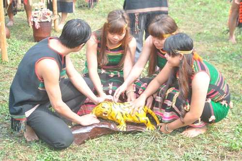 Bên cạnh ché rượu là một con cọp làm bằng gỗ.