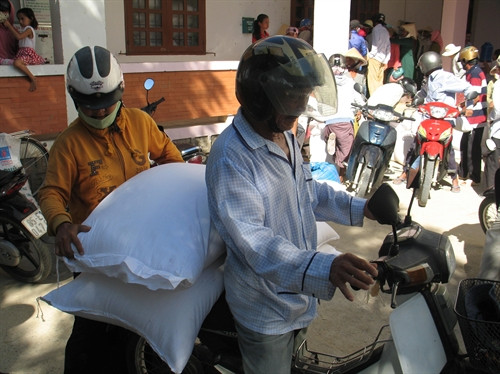 Đồng bào Chăm xã Phước Nam, huyện Thuận Nam (Ninh Thuận) nhận gạo cứu trợ của Chính phủ. Ảnh: Công Thử - TTXVN