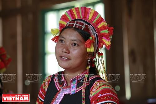 Chiếc vòng làm bằng nhựa màu nâu đỏ dùng để cố định những nếp tóc là lớp đầu tiên của khăn đội đầu người La Hủ. Lớp khăn thứ hai của chiếc khăn đội đầu của những người phụ nữ La Hủ. Nó được làm bằng vài nhiều màu và được gấp lại trước khi đội lên. Người phụ nữ La Hủ cố định lớp thứ 2 của chiếc khăn truyền thống. Sau khi đội lớp thứ 2, họ dùng dải dây thun vấn, che hết phần tóc còn lại. Lớp thứ 3 của chiếc khăn đội đầu có những sợi tua rua dài che phía sau đầu những người phụ nữ La Hủ. Thường từ lớp thứ 3 của chiếc khăn, họ cần một người khác giúp để hoàn thành chiếc khăn đội đầu sao cho đẹp nhất. Dải tua rua là lớp cuối cùng trên chiếc khăn đội đầu. Người con gái La Hủ luôn thường nuôi tóc dài để vấn tóc, đội chiếc khăn truyền thống rất cầu kỳ này. Chiếc khăn đội đầu của người phụ nữ La Hủ nhìn từ phía sau. Hai thế hệ phụ nữ người La Hủ ở Bum Tở. Vào ngày thường phụ nữ La Hủ mặc chiếc áo tà dài có màu đen truyền thống. Nhưng trong dịp lễ họ mặc thêm một chiếc áo khoác ngắn được đính trang trí khá cầu kỳ. Chiếc khăn đội đầu sặc sỡ là điểm nhấn làm nên sự khác biệt trong trang phục của người La Hủ. Những dải tua rua trên chiếc khăn đội đầu tạo nên nét rất sinh động trong trang phục của người phụ nữ La Hủ. Những cô gái La Hủ ở xã Bum Tở, huyện Mường Tè, tỉnh Lai Châu trong trang phục truyền thống đang tập múa, hát trong sân nhà văn hóa của bản.