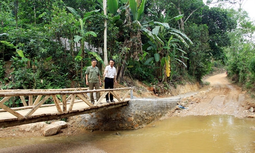 Ông Chu Văn Diu (phải) kiểm tra độ an toàn của cây cầu gỗ sau một thời gian sử dụng. Ông Chu Văn Diu (phải) kiểm tra độ an toàn của cây cầu gỗ sau một thời gian sử dụng.